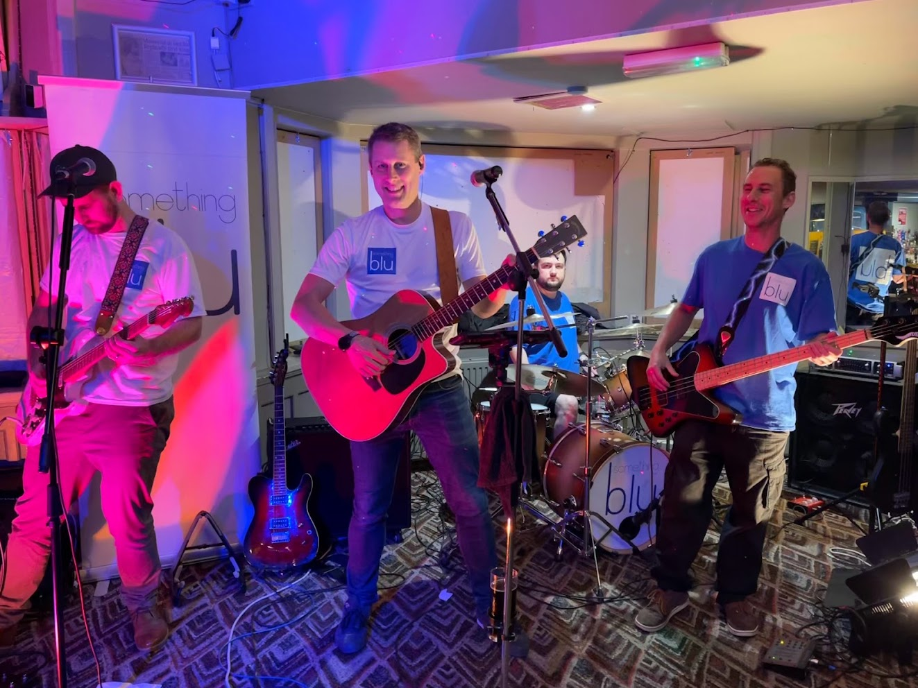 Four members of Something blu performing together with guitars and drums